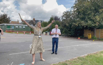 A teacher and pupil launching a rocket experiment on the school playground